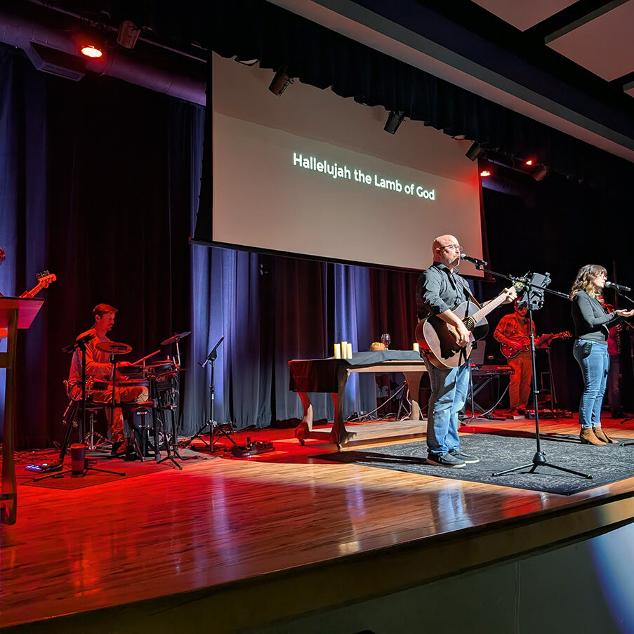 hallelujah the lamb of God on screen as band worships